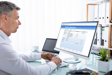 Fototapeta na wymiar Businessman Doing Online Banking On Computer