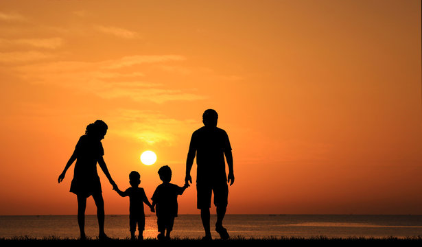 Silhouette Of Family On The Beach At  Sunrise Time