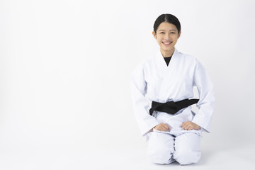 空手着を着て正座をする若い女性 © hidez