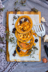 Backed and roasted sweet orange pumpkin round slices with oregano, garlic, olives and spices. Vegan lunch, vegetarian dinner, healthy food, vegetables. Delicious organic diet