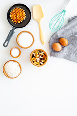 Preparing belgian waffles. Waffle on pan near whisk for whipping and ingrdients. Eggs, flour, sugar, dried fruits on white background top view space for text