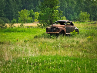 Abandoned deserted rusty old classic car in a farm field in northern Minnesota.