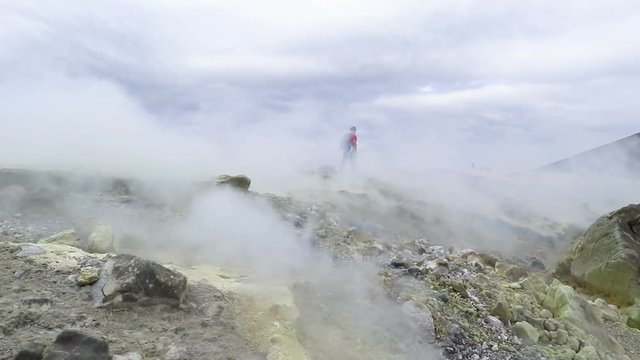 Hiker on the crater of Vulcano with sulfur fumaroles, Aeolian Islands