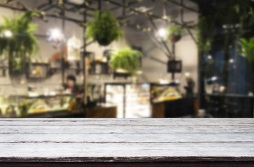 Selected focus empty brown wooden table and Coffee shop or restaurent blur background with bokeh image. for your photomontage or product display