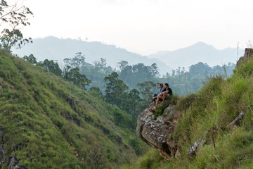 Fototapeta na wymiar Travel concept. Couple sitting on top of Small Adams peak near Ella, Sri Lanka