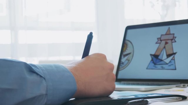 Graphic designer using graphics tablet while working on a logo design