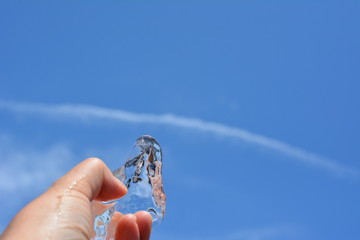 氷を持ってる手、青空、雲