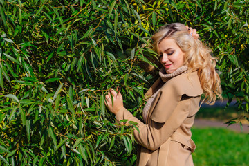 Beautiful elegant woman standing under the tree in autumn park