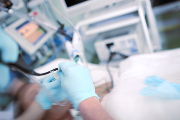 Doctor performing endoscopic procedure to the patient in the ICU