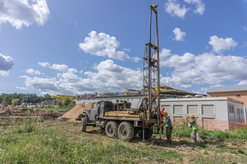 Khimki, Russia - August 24, 2018: Drilling machine, ecologist and soil samples at the construction site