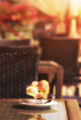 Ice cream balls mixed colors in glassware on summer terrace table in cafeteria with out of focus area for copy space