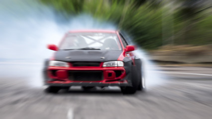 Obraz na płótnie Canvas Side view car drifting on track with grain, Sport car wheel drifting and smoking on track.