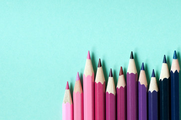 Color pencils isolated on turquoise background.
