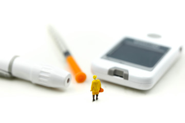 Miniature people : Doctor and patient with Glucose meter diabetes test and Syringe with measuring tape,concept of diabetes, healthy lifestyles and nutrition