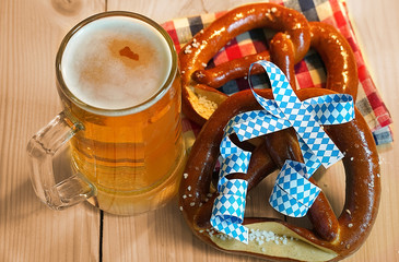 Pretzel with glass of beer on wood table for oktoberfest.