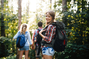 Beautiful woman and friends hiking in forest