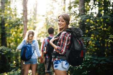 Fototapeta premium Beautiful woman and friends hiking in forest