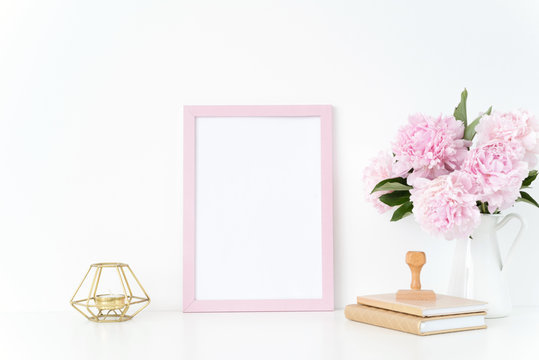 Pink summer portrait frame mock up with a pink peonies, candle and stamp beside the frame, overlay your quote, promotion, headline, or design, great for small businesses, lifestyle bloggers and social