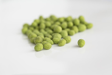 Peanuts coated with wasabi isolated on a white background