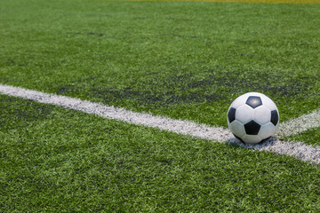 Fototapeta na wymiar soccer ball on the white line on green soccer field grass