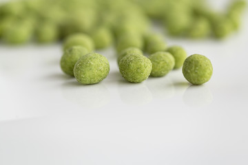 Peanuts coated with wasabi isolated on a white background