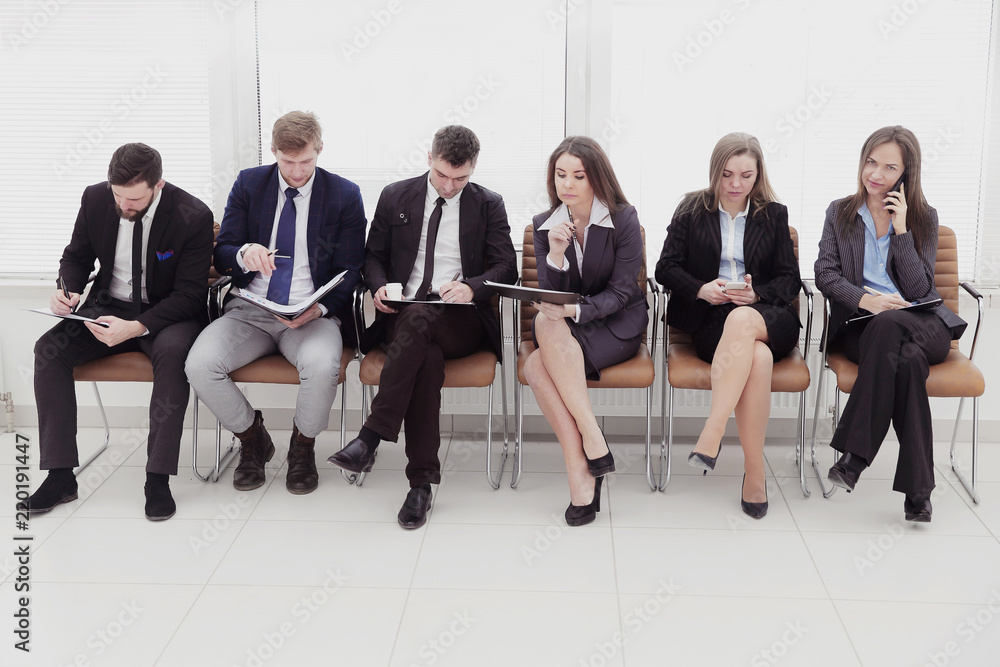 Wall mural group of business people sitting in the lobby before the interview