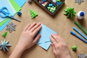 Making origami 3D Xmas tree with paper for decoration or greeting card. Merry Christmas and Happy...