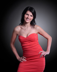 Fototapeta premium beautiful young woman in a red dress. isolated on black