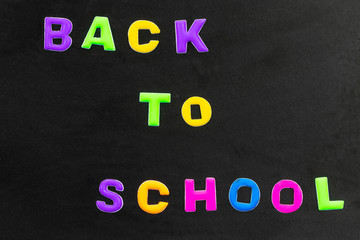 Back to school text written with colorful letters on blackboard. School board isolated on white background. Concept education.