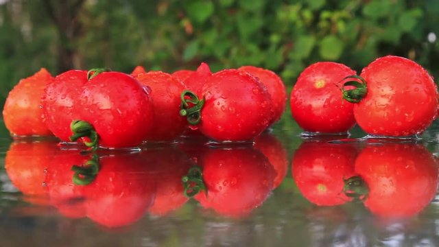 red tomatoes are lying on a glass table with a reflection