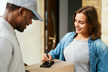Courier Delivery Service. Man Delivering Package To Woman