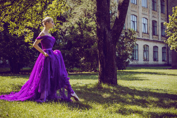 Obraz na płótnie Canvas Young Ballerina in vintage look. Ballet Dancer Girl. Image of a Dancing Woman. Lady in purple evening dress demonstrated femininity. Classical Choreography Style 