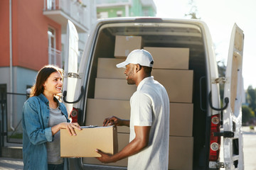 Delivery Service. Courier Delivering Package To Woman Near Car