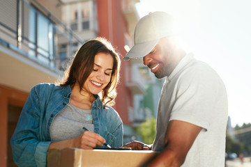 Courier Delivery Service. Man Delivering Package To Woman