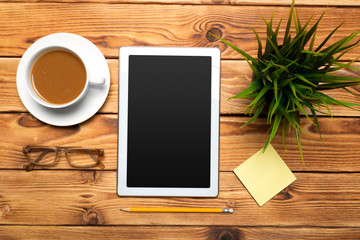digital tablet and coffee cup on wooden table