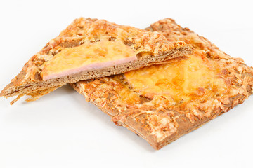 Tasty pastry of rye dough cut in half. Delicious pastries with sausage on light background. hot dog