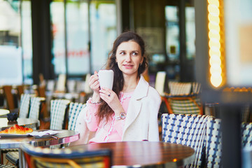 Woman drinking coffee in outdoor cafe or restaurant, Paris, France