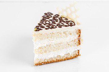 piece of cake. Layers sponge cake with creamy cream on a Plate. Sweet food and dessert. Close up.