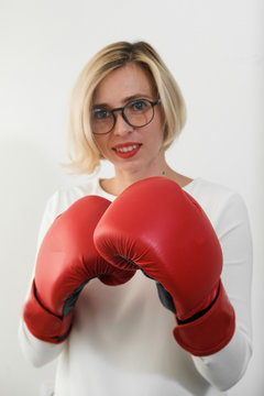 young woman with red boxing gloves. Girl in red dress are fighting, attacking and protecting.  Feminism, girl power, fight like girl, gender, woman rights concept. Focus on gloves.