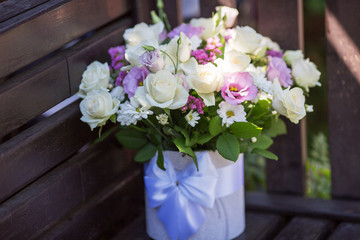 a bouquet of roses for a holiday. Roses are white and lilac in a decorated box.