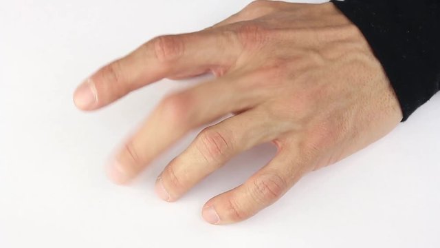 human hand nervously knocking fingers on white table