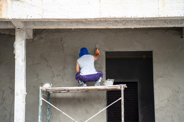 construction workers plastering building wall and beam using cement plaster mix of cement and sand at the construction site in thailand
