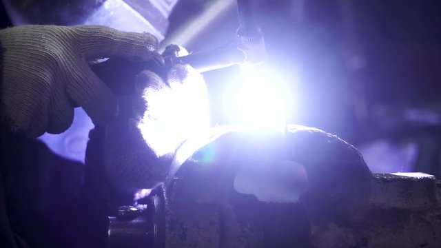 Industrial worker welding, slow motion. Clip. Metal Welding Close-Up in super slow motion. Close-up. Welder in protective clothing working with metal, welding metal. Slow motion.