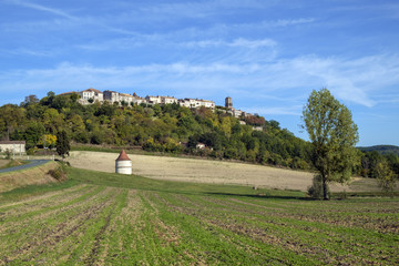 Looking up at picturesque hilltop town of Tournon d'Agenais in rural Lot et Garonne countryside,...