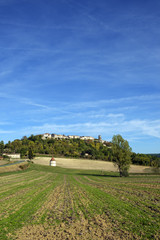 Looking up at picturesque hilltop town of Tournon d'Agenais in rural Lot et Garonne countryside,...