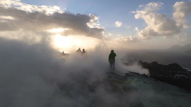 Hikers at sunset on the crater of Vulcano with sulfur fumaroles, Aeolian Islands