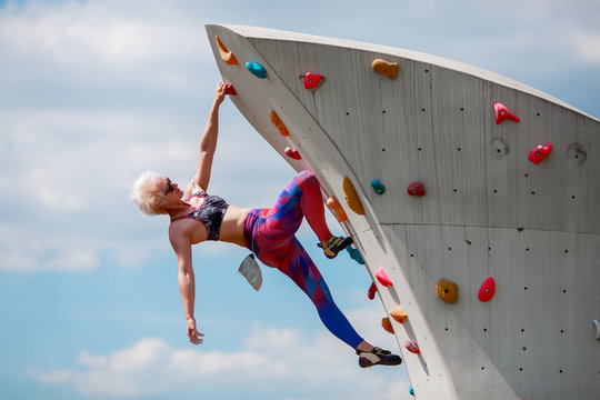 Photo of young sportswoman on workout on climbing wall