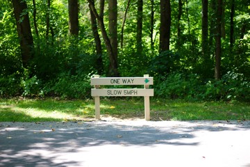 A small wooden sign in the campground area of park.