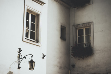 vintage outdoor concept shot of narrow european street exterior corner building space with white wall lantern and windows