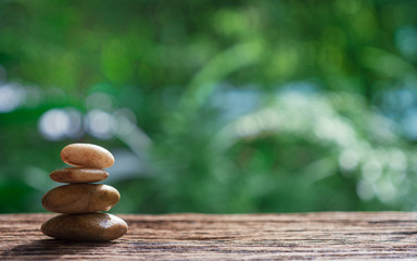 Obraz na płótnie Canvas Balance Zen stones on wood with green nature bokeh background.
